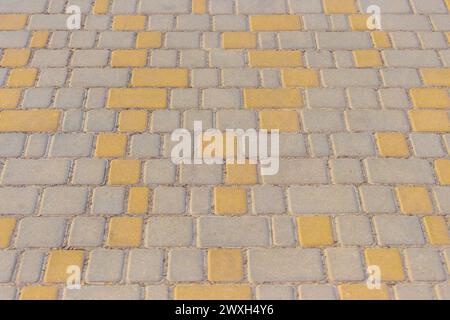 Gelbe Farbe Diagonale Muster Linien Streifen Pflastersteinboden Oberfläche Straße Straße Stadt Textur Hintergrund Fliese. Stockfoto