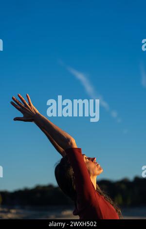 Frau meditiert Yoga mit blauem Himmel im Hintergrund Stockfoto