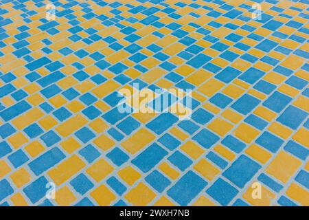 Blau Gelb Helle Farbe Diagonale Muster Linien Streifen Pflastersteinboden Oberfläche Straße Straße Stadt Textur Hintergrund Fliese. Stockfoto