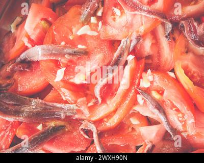 Frische rote Paprika und verschiedene Gemüsesorten in einer Schüssel mit einem gelben Messer Stockfoto