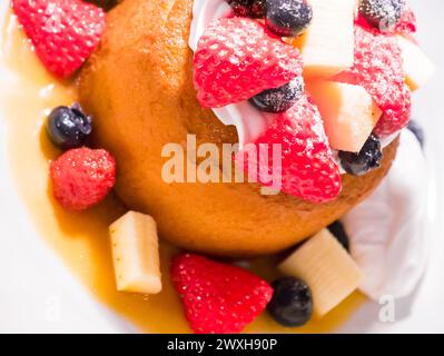 Apfel in der Tasse, umgeben von Früchten mit einem Niesel Stockfoto