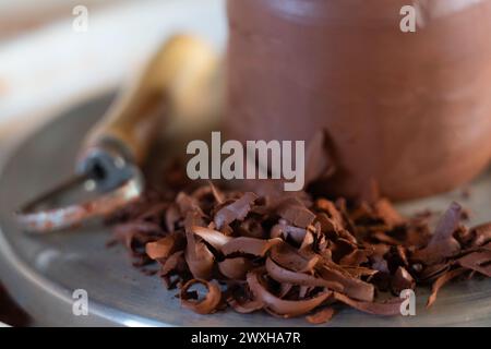 Tonstück aus nächster Nähe mit Töpferwerkzeugen und Tonspänen auf einem Töpferrad Stockfoto