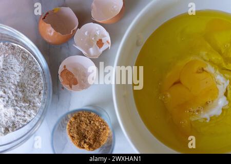 Schüssel mit Zutaten, um einen Biskuitkuchen zu machen Stockfoto
