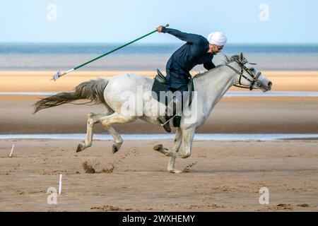 Altes Kavallerie-Spiel „Zelt-Pegging“ Reiter in Southport, Merseyside, 31.03.2024. Eine Gruppe von Männern spielt ihren Lieblingssport am Strand von Southport in der wunderschönen Ostersonne. Das Spiel, in Pakistan auch als Neza Bazi bekannt, ist eine Reitersportart uralten Ursprungs und ist eine von nur zehn von der International Equestrian Federation offiziell anerkannten Reitdisziplinen. Quelle: Cernan Elias/Alamy Live News Stockfoto