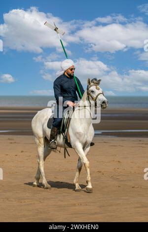 Altes Kavallerie-Spiel „Zelt-Pegging“ Reiter in Southport, Merseyside, 31.03.2024. Eine Gruppe von Männern spielt ihren Lieblingssport am Strand von Southport in der wunderschönen Ostersonne. Das Spiel, in Pakistan auch als Neza Bazi bekannt, ist eine Reitersportart uralten Ursprungs und ist eine von nur zehn von der International Equestrian Federation offiziell anerkannten Reitdisziplinen. Quelle: Cernan Elias/Alamy Live News Stockfoto