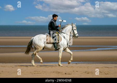 Altes Kavallerie-Spiel „Zelt-Pegging“ Reiter in Southport, Merseyside, 31.03.2024. Eine Gruppe von Männern spielt ihren Lieblingssport am Strand von Southport in der wunderschönen Ostersonne. Das Spiel, in Pakistan auch als Neza Bazi bekannt, ist eine Reitersportart uralten Ursprungs und ist eine von nur zehn von der International Equestrian Federation offiziell anerkannten Reitdisziplinen. Quelle: Cernan Elias/Alamy Live News Stockfoto