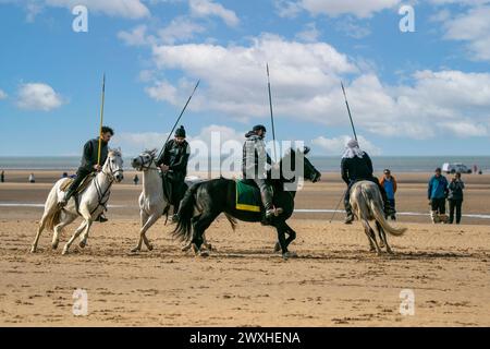 Altes Kavallerie-Spiel „Zelt-Pegging“ Reiter in Southport, Merseyside, 31.03.2024. Eine Gruppe von Männern spielt ihren Lieblingssport am Strand von Southport in der wunderschönen Ostersonne. Das Spiel, in Pakistan auch als Neza Bazi bekannt, ist eine Reitersportart uralten Ursprungs und ist eine von nur zehn von der International Equestrian Federation offiziell anerkannten Reitdisziplinen. Quelle: Cernan Elias/Alamy Live News Stockfoto