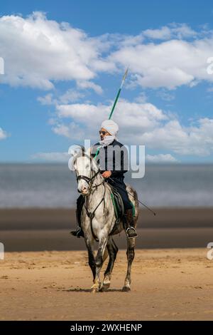 Altes Kavallerie-Spiel „Zelt-Pegging“ Reiter in Southport, Merseyside, 31.03.2024. Eine Gruppe von Männern spielt ihren Lieblingssport am Strand von Southport in der wunderschönen Ostersonne. Das Spiel, in Pakistan auch als Neza Bazi bekannt, ist eine Reitersportart uralten Ursprungs und ist eine von nur zehn von der International Equestrian Federation offiziell anerkannten Reitdisziplinen. Quelle: Cernan Elias/Alamy Live News Stockfoto