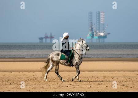 Altes Kavallerie-Spiel „Zelt-Pegging“ Reiter in Southport, Merseyside, 31.03.2024. Eine Gruppe von Männern spielt ihren Lieblingssport am Strand von Southport in der wunderschönen Ostersonne. Das Spiel, in Pakistan auch als Neza Bazi bekannt, ist eine Reitersportart uralten Ursprungs und ist eine von nur zehn von der International Equestrian Federation offiziell anerkannten Reitdisziplinen. Quelle: Cernan Elias/Alamy Live News Stockfoto