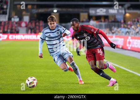 Toronto, Kanada. 30. März 2024. Toronto FC Stürmer Tyrese Spicer (16) spielt den Ball gegen den Mittelfeldspieler aus Kansas City Jake Davis (17) während der zweiten Hälfte eines MLS-Fußballspiels in Toronto am Sonntag, den 30. März 2024. (Foto: Michael Chisholm/SIPA USA) Credit: SIPA USA/Alamy Live News Stockfoto