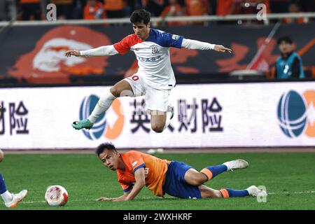 Jinan, Chinas Provinz Shandong. 31. März 2023. Joao Teixeira (Top) aus Shanghai Shenhua wetteift um den Ball während des 3. Runde Spiels der chinesischen Fußballverbände Super League (CSL) 2024 zwischen Shangdong Taishan und Shanghai Shenhua in Jinan, ostchinesische Provinz Shandong, am 31. März 2023. Quelle: Zhu Zheng/Xinhua/Alamy Live News Stockfoto