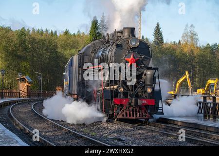 RUSKEALA, RUSSLAND - 06. OKTOBER 2023: Die alte Dampflokomotive L-5164 mit Retro-Zug 'Ruskeala Express' kommt auf einer an der Station Ruskeala Mountain Park an Stockfoto