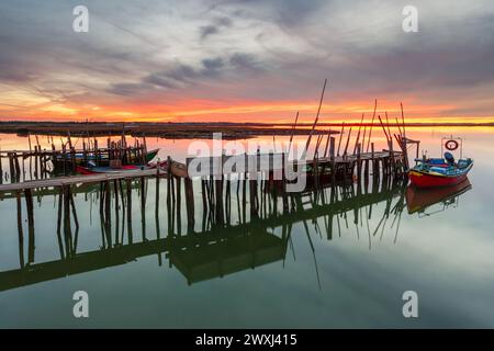 Atemberaubender Sonnenuntergang auf dem palastartigen Pier von Carrasqueira, Alentejo, Portugal. Handwerklicher Fischereihafen aus Holz mit traditionellen Booten auf dem Fluss Sado. Gut, gut Stockfoto