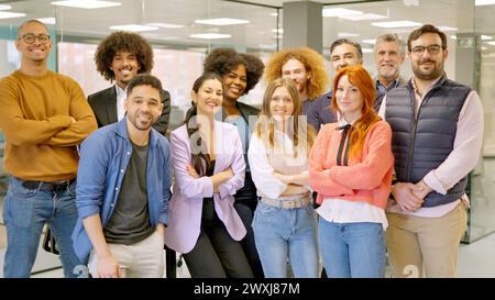 Eine Gruppe von Kollegen lächelt in einem Coworking Space in die Kamera Stockfoto