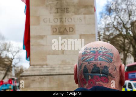 London, Großbritannien. März 2024. Ein Mann mit Tätowierungen auf dem Kopf steht vor der Gedenkstätte Cenotaph in Whitehall in London. Ein Demonstrant ruft britische Militärveteranen ein Ende - die meisten Veteranen sind alte Menschen und sie werden für die Strafverfolgungsmaßnahmen vor Jahrzehnten zur Verantwortung gezogen. (Foto: Thabo Jaiyesimi/SOPA Images/SIPA USA) Credit: SIPA USA/Alamy Live News Stockfoto