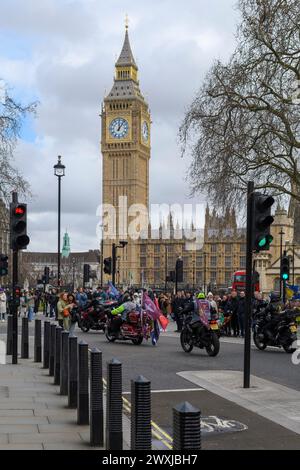 Motorradbegeisterte passieren Elizabeth Tower und Big Ben auf den Straßen von Westminster, London, während der Oster-Motorradrallye am Karfreitag 2024 Stockfoto