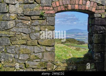 Der Wrekin wird durch die Industrieruinen von Abdon Burf, Brown Clee Hill, in der Nähe von Cleobury North, Burwarton, Shropshire, gesehen Stockfoto