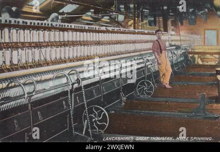 "Lancashire's Great Industry: Mule Spinning": Farbige Fotografie, die als Postkarte von L. Pickles & Co., Bradford, im frühen 20. Jahrhundert veröffentlicht wurde. Es zeigt einen Jungen, der sich an eine Maultierspinnmaschine in einer Baumwollmühle von Lancashire lehnt Stockfoto