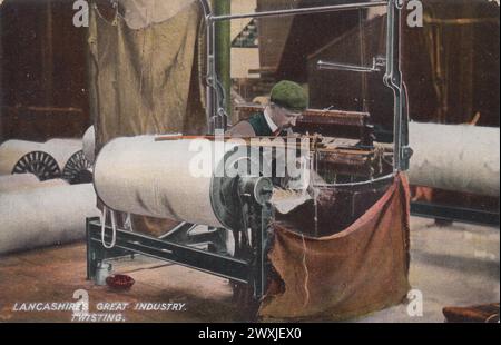 "Lancashire's Great Industry: Twisting": Farbgetönte Fotografie, die als Postkarte von L. Pickles & Co., Bradford, im frühen 20. Jahrhundert veröffentlicht wurde. Es zeigt einen Mann in einer Stoffmütze, der in einer Baumwollmühle von Lancashire auf einer Drehmaschine arbeitet, mit riesigen Rollen Baumwolle im Hintergrund Stockfoto