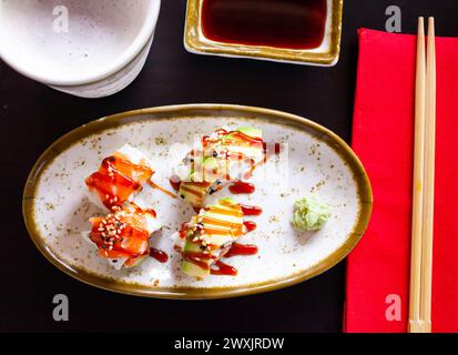 Uramaki mit Lachs, Avocado, Unagi-Sauce und Sesam Stockfoto