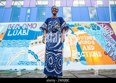 Mrs. Gbemi Isimi steht vor dem Yoruba Heritage Mural, das vor dem Peckham Lesuire Center am Peckham Square im Südosten Londons enthüllt wurde. Dieses Projekt, das von Frau Gbemi Isimi von Culture Tree geleitet wurde, wurde vom Bürgermeister von London finanziert und vom Southwark Council unterstützt. Stockfoto