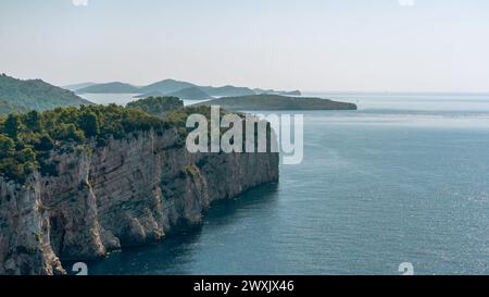 Panoramablick auf die Sommerlandschaft der Insel Dugi otok im Nationalpark Telascica, Kroatien. Blick aus der Vogelperspektive auf die mit grünem Wald bedeckten Klippen Stockfoto