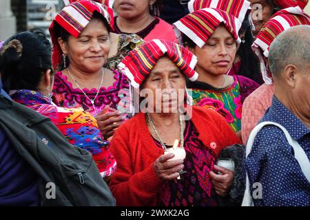 Chichicastenango, Guatemala. 30. März 2024. Indigene Maya-Frauen, die traditionelle Huipiles tragen, halten während einer christlichen und Maya-Zeremonie für Jesus am Heiligen Samstag im Cementerio de Chichicastenango, 30. März 2024, in Chichicastenango, Guatemala, brennende Kerzen. Die katholische Kirche und die Maya-Glaubenssätze haben sich vor langer Zeit in den indigenen Regionen Guatemalas in einem Prozess gemischt, der Synkretismus genannt wird. Quelle: Richard Ellis/Richard Ellis/Alamy Live News Stockfoto