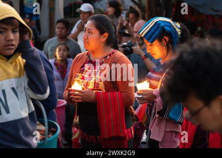 Chichicastenango, Guatemala. 30. März 2024. Indigene Maya-Frauen, die traditionelle Huipiles tragen, halten Kerzen auf den Stufen der Kirche Iglesia de Santo Tomás vor einer Mahnwache zum Heiligen Samstag, dem 30. März 2024 in Chichicastenango, Guatemala. Die katholische Kirche und die Maya-Glaubenssätze haben sich vor langer Zeit in den indigenen Regionen Guatemalas in einem Prozess gemischt, der Synkretismus genannt wird. Quelle: Richard Ellis/Richard Ellis/Alamy Live News Stockfoto