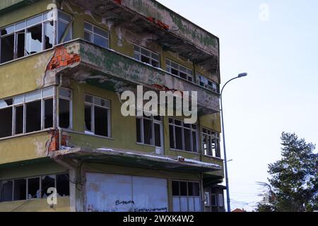 Altes Wohngebäude mit kaputten Fenstern und beschädigten Wänden tagsüber in der Stadt Stockfoto