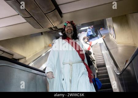 London, Großbritannien. 31. März 2024. Ein Teilnehmer, der sich als Jesus verkleidet hat, fährt während des jährlichen Fancy Dress Pub Crawl Events durch die Londoner U-Bahn zu ihrem nächsten Ziel. Eine Gruppe von Pub Crawl-Enthusiasten, verkleidet als Jesus und andere biblische Charaktere, nehmen am jährlichen Christathon Teil, einem Kneipenbummel im Zentrum von London am Ostersonntag. Dies ist der 17. Jahrestag der jährlichen Kneipenbummel mit dem Thema Crucifixion. (Foto: Hesther ng/SOPA Images/SIPA USA) Credit: SIPA USA/Alamy Live News Stockfoto