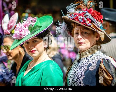 Eine Paradeteilnehmerin zeigt ihre alte Haube. Heute geht in New York City eine Tradition weiter, die Osterbonnet Parade. Obwohl es keine Parade ist, ziehen sich Menschen mit maßgeschneiderten Hauben vor der St. Patrick's Cathedral. Leute aus der ganzen Welt kommen, um es zu sehen, zu fotografieren und sich diesen Ostersonntag ein wenig inspirieren zu lassen. Die Easter Bonnet Parade in NYC geht auf das Ende des 19. Jahrhunderts zurück, als wohlhabende New Yorker nach dem Besuch der Ostergottesdienste entlang der Fifth Avenue spazieren gingen. Im frühen 20. Jahrhundert wurde es zu einer jährlichen Tradition und entwickelte sich zu einer lebendigen Ausstellung von raffinierten und kreativen Werken Stockfoto