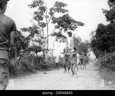 Vietnamkrieg: Mitglieder des 3. Bataillons, 187. Infanterie, 101. Airborne Division (Airmobile), schließen sich den Kindern von AP Uu Thoung bei einem Baseballspiel an. 1970 Stockfoto