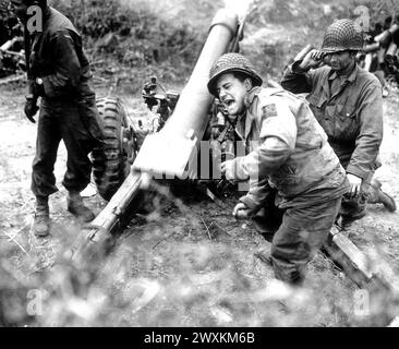 Amerikanische Haubitzen beschießen deutsche Truppen, die sich in der Nähe von Carentan, Frankreich, CA. Zurückziehen. 1944 Stockfoto