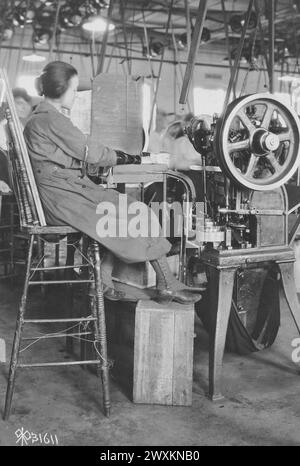 (Originalunterschrift) Arbeiterinnen in Munitionsanlagen: Frau, die an einer Verschließmaschine in der Fabrik der US-amerikanischen Cartridge Company in Lowell, MA CA. Arbeitet. 1919 Stockfoto