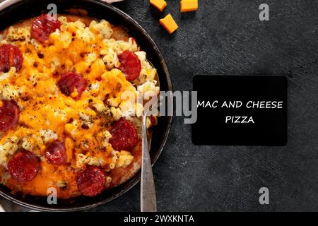Trendiges Hybrid-Essen. Mac und Käse Pizza auf dunklem Hintergrund. Draufsicht Stockfoto