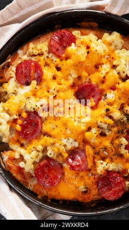 Trendiges Hybrid-Essen. Mac und Käse Pizza auf dunklem Hintergrund. Draufsicht, Kopierraum Stockfoto