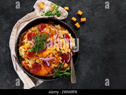 Trendiges Hybrid-Essen. Mac und Käse Pizza auf dunklem Hintergrund. Draufsicht Stockfoto