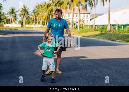 Vater Sohn, viel Spaß. Der Mann hält das Bein des Kindes auf dem Kopf. Freude Glück Kindheit Vaterschaft Freude Stockfoto