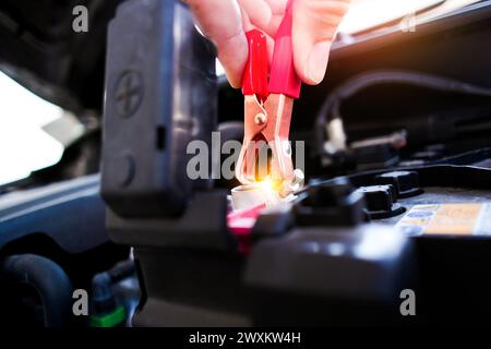 Auto Mechanic klemmt Batterieklemmen mit Batterieladeklammern , Kfz-Wartungskonzept Stockfoto