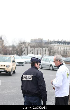 Polizist streitet mit einem Mann, der einen Kopf in paris hält, am Triumphbogen in paris 2009 Stockfoto