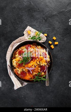 Trendiges Hybrid-Essen. Mac und Käse Pizza auf dunklem Hintergrund. Draufsicht Stockfoto
