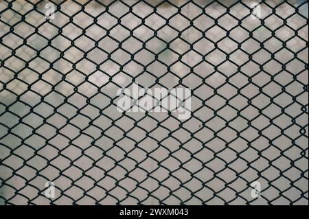 Tennisball in einem Drahtkäfig gegen bewölkten Himmel Stockfoto