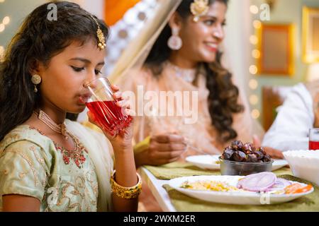 Nahaufnahme eines indischen Mädchens, das während des ramadan iftar-Dinners zu Hause Rose trinkt - Konzept der religiösen Kultur, ramzan festlich und Stockfoto