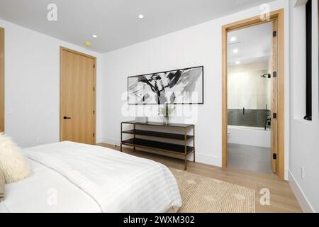 Ein geräumiges Schlafzimmer mit einem Kingsize-Bett und einem Bild an der Wand. Stockfoto