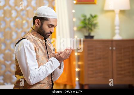 Seitenansicht eines jungen indischen muslimischen Mannes, der während des Ramdan-Festivals zu Hause heilige Namen macht - Konzepttredition, Kultur und festliche Feier. Stockfoto
