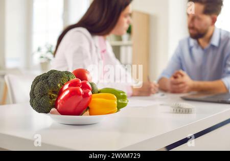 Gemüseplatte aus nächster Nähe, frischer Brokkoli, roter, grüner Pfeffer an der Rezeption des Ernährungsberaters Stockfoto