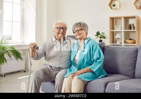 Glückliches Ehepaar der älteren Familie, Frau und Mann, die zu Hause auf dem Sofa im Wohnzimmer sitzen. Stockfoto