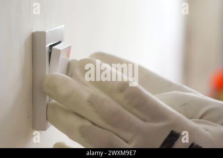 Installation eines elektrischen Schalters an der Wand während der Renovierung der Wohnung Stockfoto
