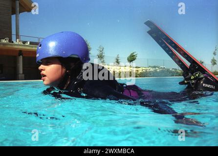 Ein junger (Teenager) Freestyle-Ski-Jumperin landet in einem Pool von einer speziell gebauten Rampe in der Olympischen Trainingsanlage in Park City, Utah - der Pool bricht den Fall für alle Stockfoto