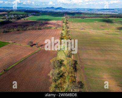 Aus der Vogelperspektive der Dere Street Römerstraße mit Blick nach Norden in Richtung der Eildon Hills (lateinisch: trium montium, drei Hügel) bei Melrose. Stockfoto